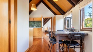 A modern kitchen with wooden cabinets and a large window. - Merivale | King Bed + Carpark, Walk to Hagley Park (Christchurch)