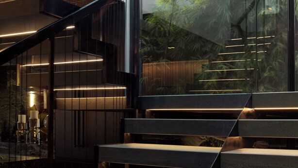 A modern staircase with glass railings and integrated lighting, leading to a second-floor area with a view of greenery outside. - Luxury Paddington Townhouse (Darlinghurst)