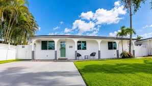 A single-story house with a front porch, a driveway, and a well-maintained lawn. - Luxury Pool Home, Near the Beach and Cruise Port (Dania Beach)
