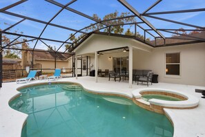 Una piscina esterna coperta con lettini e una zona solarium.