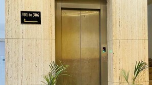 An elevator with a sign indicating floors 301 to 306, flanked by two potted plants. - Hotel Sun Park Bhopal (Bhopal)