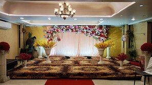 Un escenario con un fondo floral, una araña y una alfombra estampada.