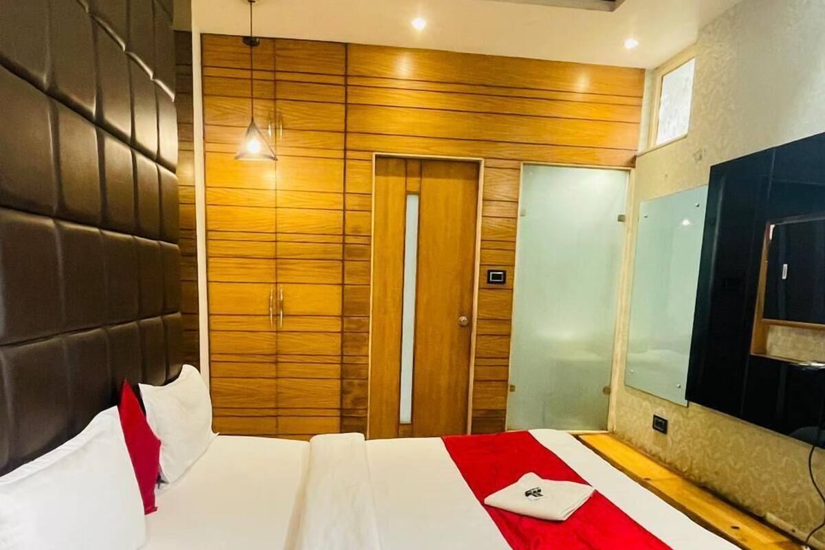 Ein modernes Hotelzimmer mit einem großen Bett, Holzwänden, einem Fernseher und einer Tür.