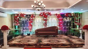 A stage with a sofa, floral decorations, and a chandelier. - Hotel Sun Park Bhopal (Bhopal)