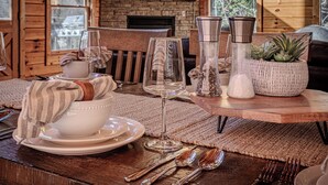 A wooden dining table set with white plates, bowls, and cutlery, a glass, and a woven pot with a plant. - Labor Day & Fall Getaway, Epic Mountain Views, Hot Tub, Near Dollywood (Sevierville)