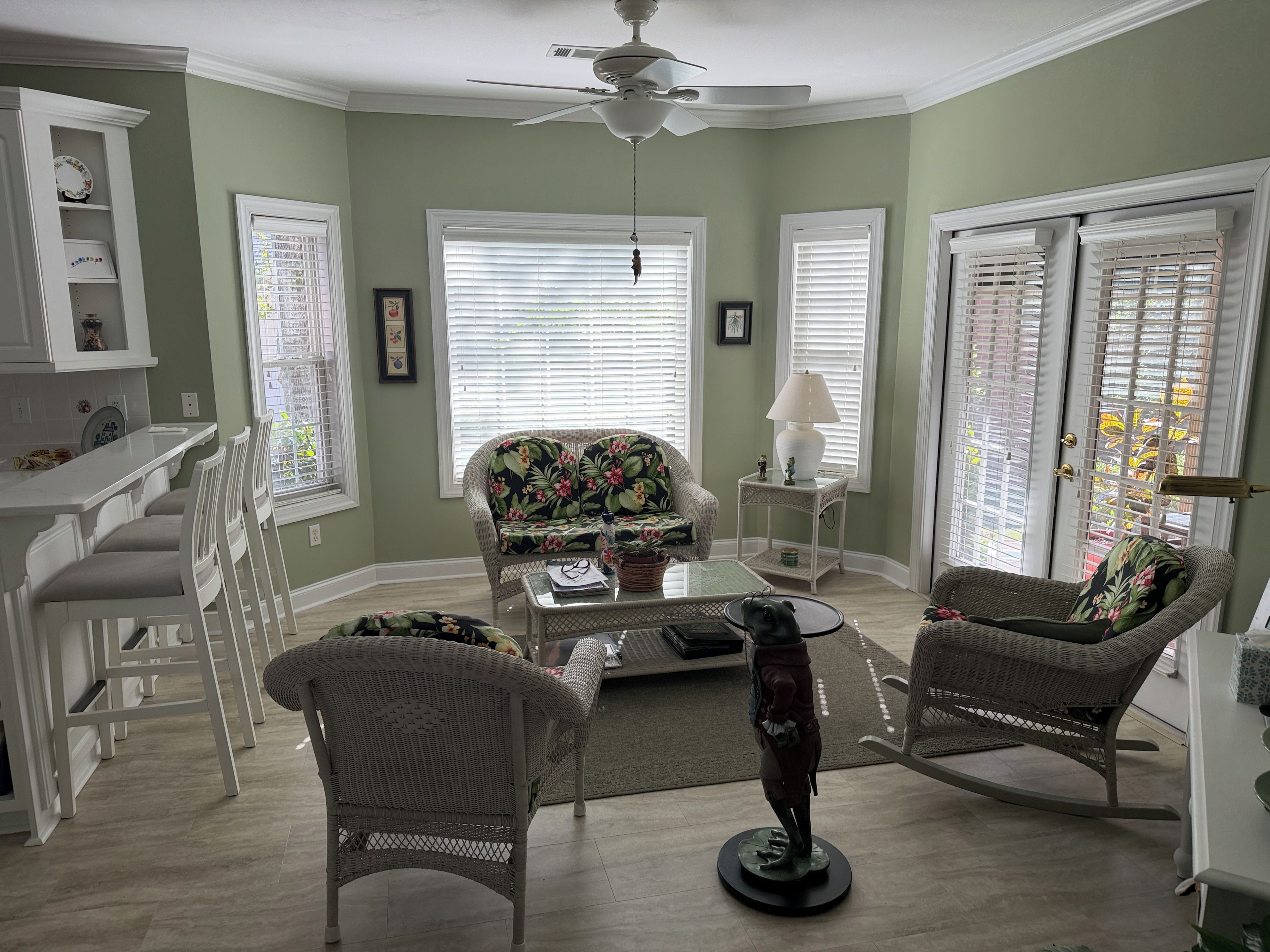 A living room with a sofa, chairs, a coffee table, and a ceiling fan.