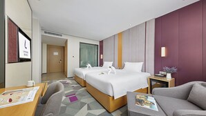A hotel room with two beds, a sofa, a small table, and a TV. - Lavande International Hotel Guangzhou Baiyun International Airport Renhe Metro Station Branch (Guangzhou)