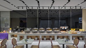 A modern buffet setup with multiple serving stations and seating arrangements. - Lavande International Hotel Guangzhou Baiyun International Airport Renhe Metro Station Branch (Guangzhou)