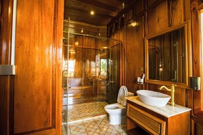 Traditionele boomhut, balkon, uitzicht op tuin | Badkamer | Een aparte badkuip en douche, pantoffels, handdoeken, zeep