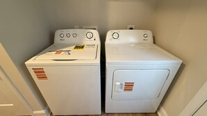 Una sala de bugaderia amb dues rentadores blanques de càrrega frontal.