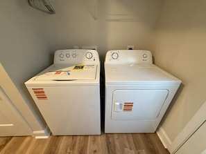 Une buanderie équipée de deux machines à laver à chargement frontal, toutes deux de couleur blanche.