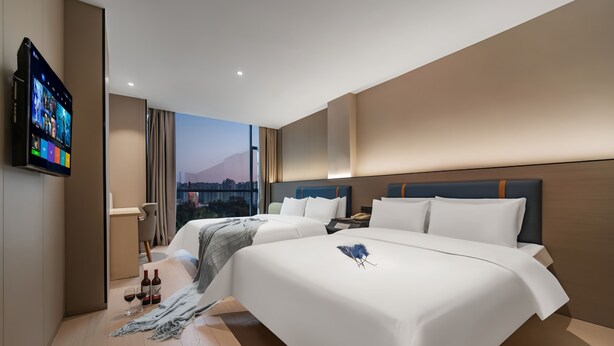 Habitación de hotel moderna con dos camas, televisión y vistas a la ciudad.