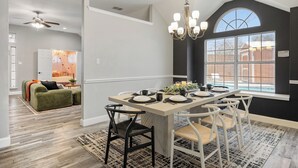 A dining area with a central island, white chairs, and a chandelier. - FIFA2026, Pool + FREE Heated Spa, ATTstadium, Six Flag (Grand Prairie)
