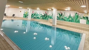 An indoor swimming pool with wooden ceiling beams, tiled floor, and a mural of plants on the wall. - Studio im Zentrum, Schwimmbad und 400m von Skiliften entfernt by Interhome (St. Moritz)