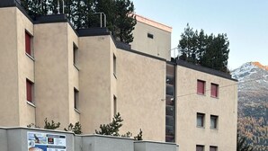 A building with a ground-floor restaurant and a parking sign. - Studio im Zentrum, Schwimmbad und 400m von Skiliften entfernt by Interhome (St. Moritz)