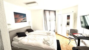 A hotel room with two beds, a desk with a computer, a TV, and a wardrobe. - Studio im Zentrum, Schwimmbad und 400m von Skiliften entfernt by Interhome (St. Moritz)