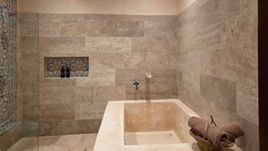 A bathroom with a bathtub, a shelf with toiletries, and a towel basket. - Casa Lucia B&B Valladolid  (Valladolid)