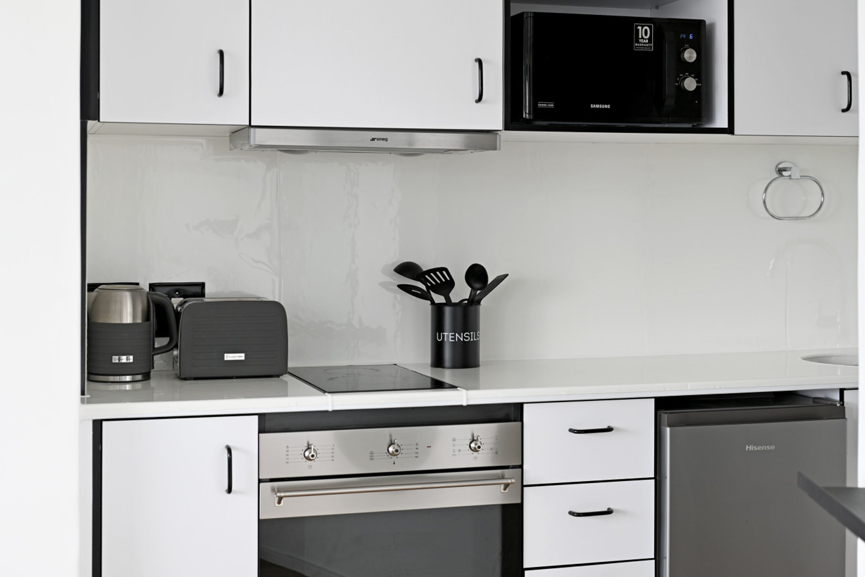 Een moderne keuken met een magnetron, broodrooster, koffiezetapparaat en oven.