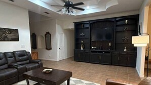 A living room with a sofa, coffee table, and entertainment center. - Spacious 5-bedroom  3.5 bath home on 1/2 an acre in Mission.  Pet friendly. (Mission)