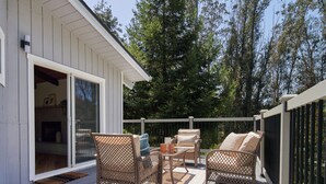 A deck with wicker furniture and a sliding glass door leading to an interior space. - Aptos Hills Getaway - Welcome to Oak Landing (Aptos)