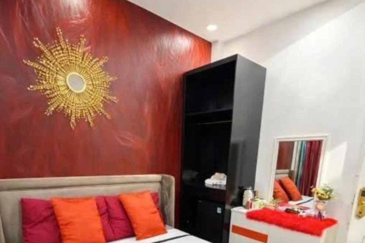 A modern bedroom with a large bed, a wardrobe, and a mirror.