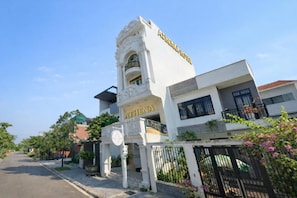 A hotel named 'ATHENA HOTEL' with a classical architectural style, a gated entrance, and a clear sky. - Athena Hotel (Thuy Xuan)