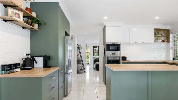 Una cucina moderna con isola centrale, elettrodomestici integrati e un design pulito e minimalista.