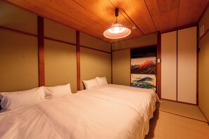 Une chambre à coucher avec un lit, un plafond en bois et un tableau représentant une montagne.