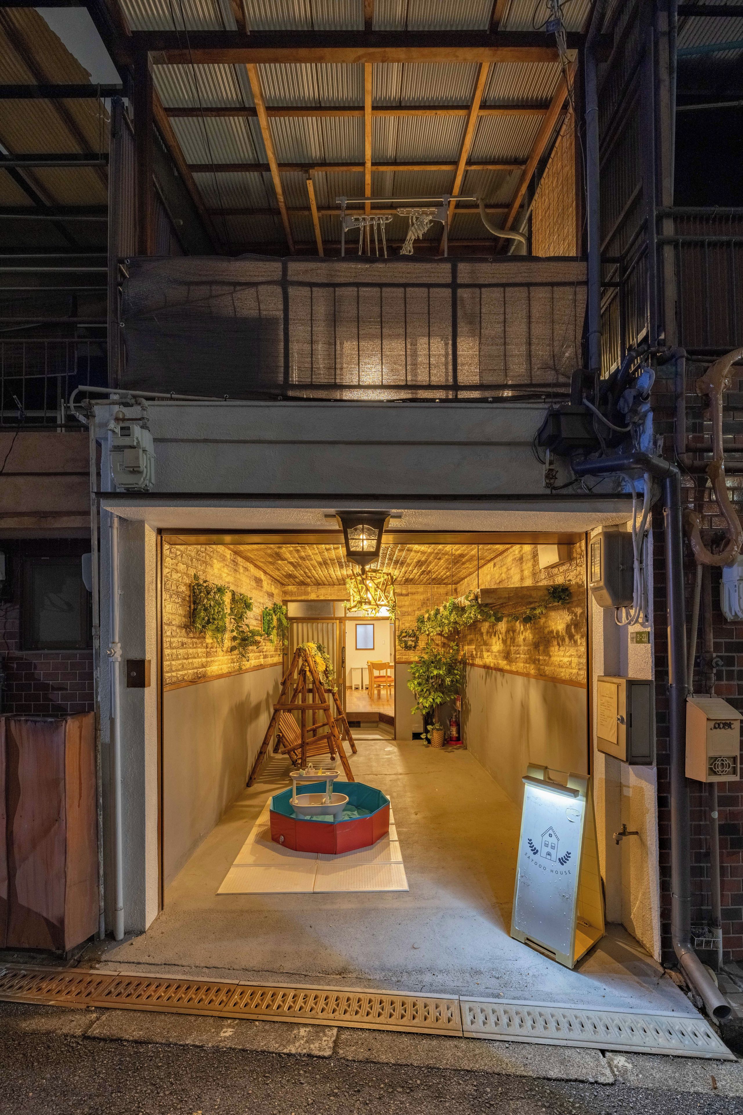 A spacious interior with a high ceiling, a central wooden ladder, and a small circular table.