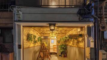 A spacious interior with a high ceiling, a central wooden ladder, and a small circular table.