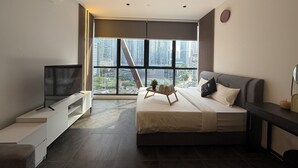 A modern bedroom with a bed, a TV, a ceiling fan, and a large window offering a city view. - Metahome@Scarletz Suites KLCC (Kuala Lumpur)