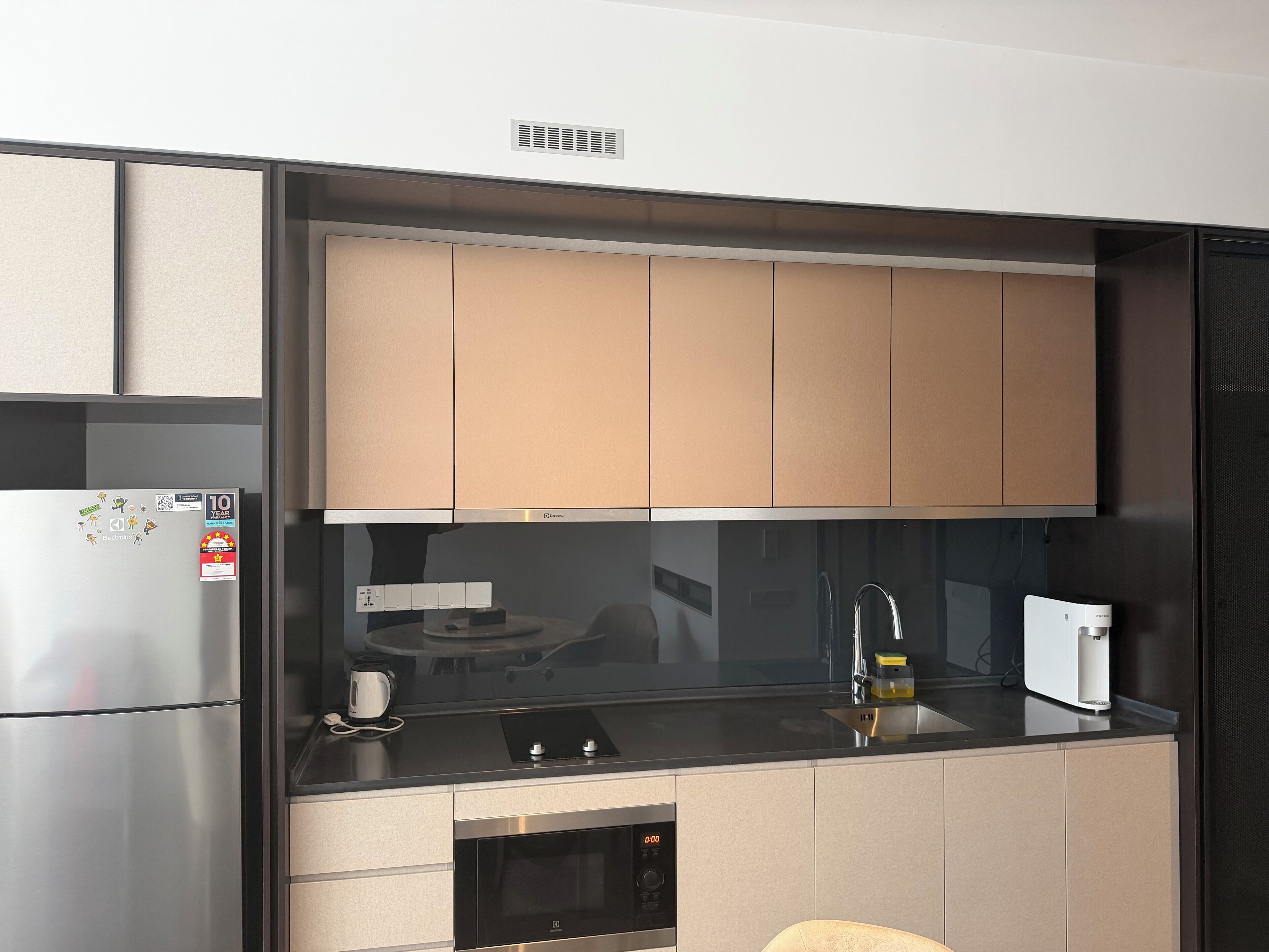 Eine moderne Küche mit eingebautem Backofen, Kaffeemaschine und Wasserkocher auf der Arbeitsfläche.