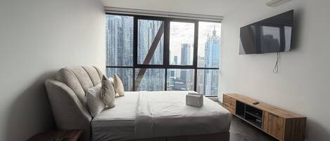 Una camera da letto moderna con un'ampia finestra, un letto, una televisione e un armadio in legno.