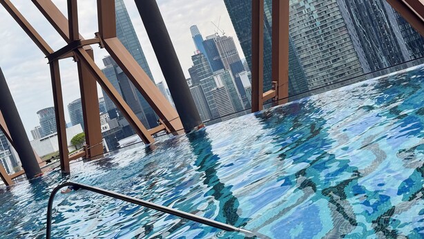 An indoor swimming pool with a view of tall buildings in the background. - Metahome@Scarletz Suites KLCC (Kuala Lumpur)