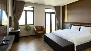 Una habitación de hotel moderna con una cama grande, un escritorio, una silla y un televisor.