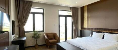 Una habitación de hotel moderna con una cama grande, un escritorio, una silla y un televisor.