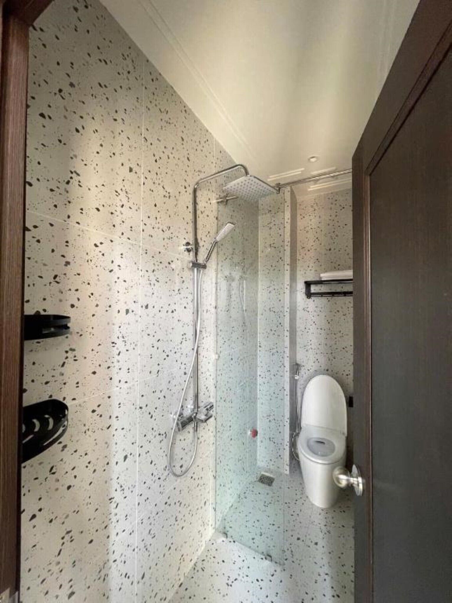 Un baño pequeño con ducha, inodoro y espejo.