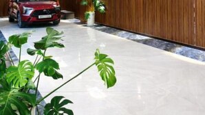 Un interior moderno con un coche rojo, paneles de madera y suelo de mármol.