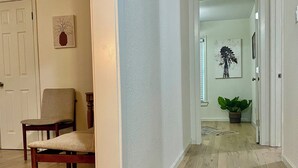 A hallway with wooden flooring, a chair, a rug, and a door leading to another room. - Location! Charming neighborhood Newly renovated Modern furnishings  Fab Staycay (Fort Worth)