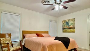 A bedroom with a bed, a chair, a ceiling fan, and a painting on the wall. - Location! Charming neighborhood Newly renovated Modern furnishings  Fab Staycay (Fort Worth)