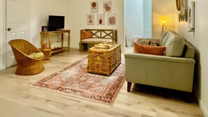 A living room with a sofa, a wicker chair, a coffee table, and a television. - Location! Charming neighborhood Newly renovated Modern furnishings  Fab Staycay (Fort Worth)