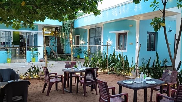 Un bâtiment bleu doté d’une terrasse et agrémenté de plantes.