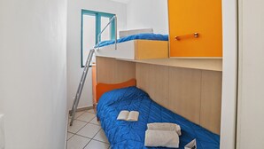 A dormitory room with bunk beds, a ladder, a door, and a window. - SeaEscape San Foca - Duplex with Sea-View Balcony, Melendugno, Italy (Melendugno)