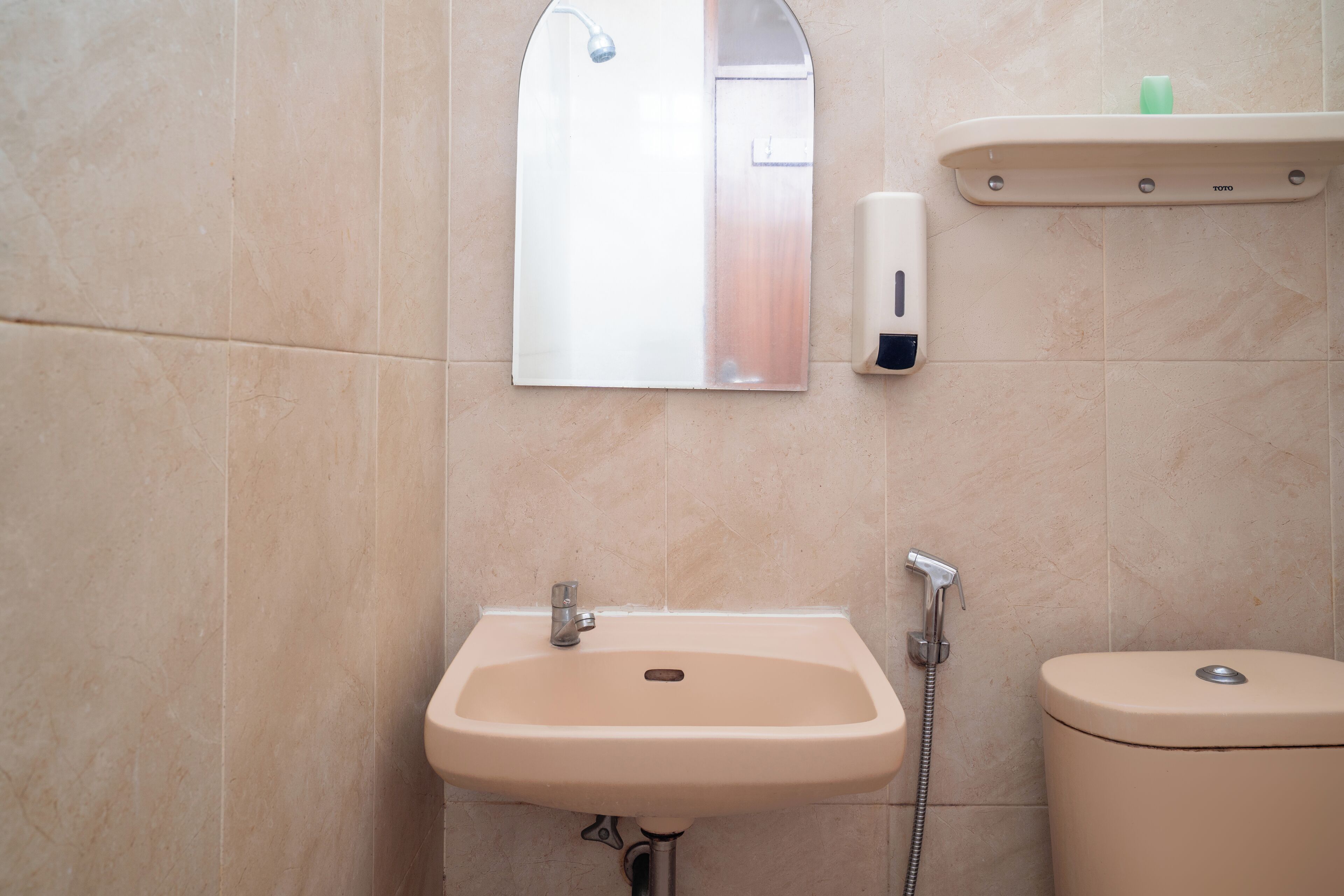 A bathroom with a sink, mirror, and toilet.
