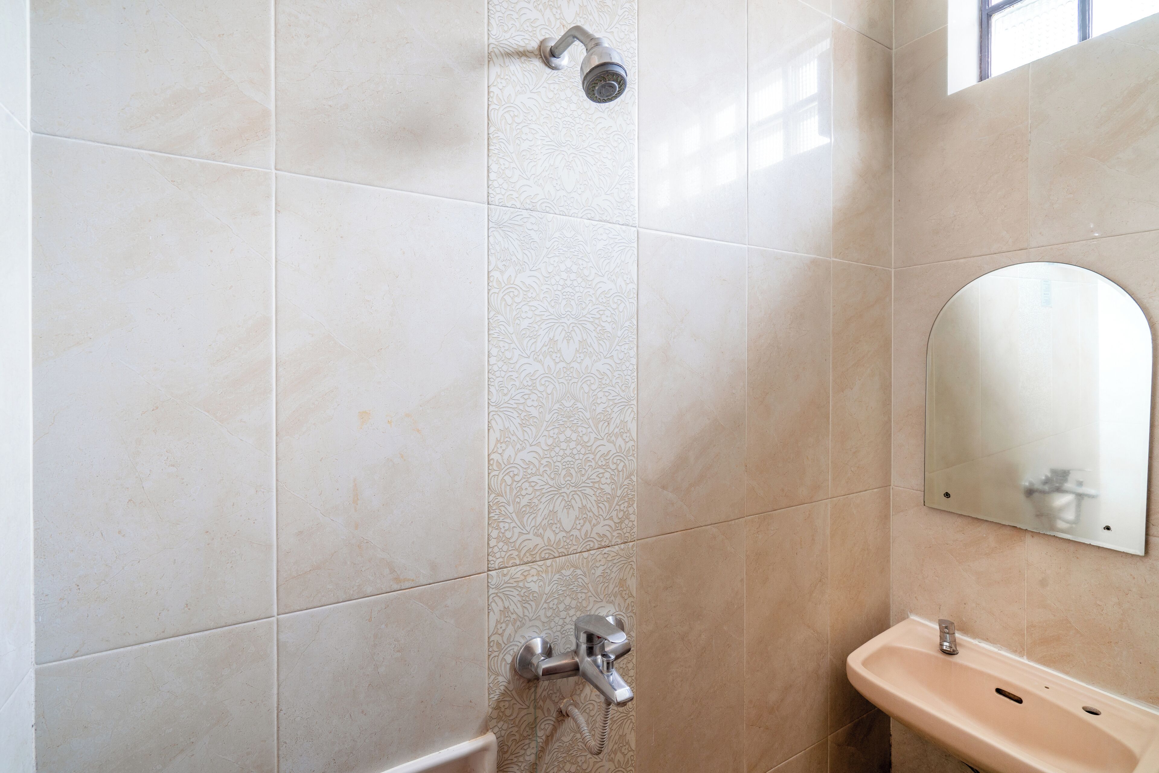A bathroom with a shower, sink, and mirror.