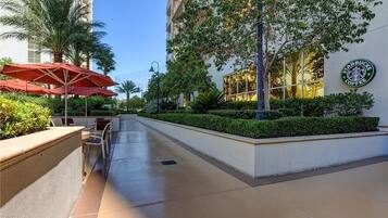 Corridoio di un hotel con posti a sedere all'aperto, palme e un cartello Starbucks Coffee.