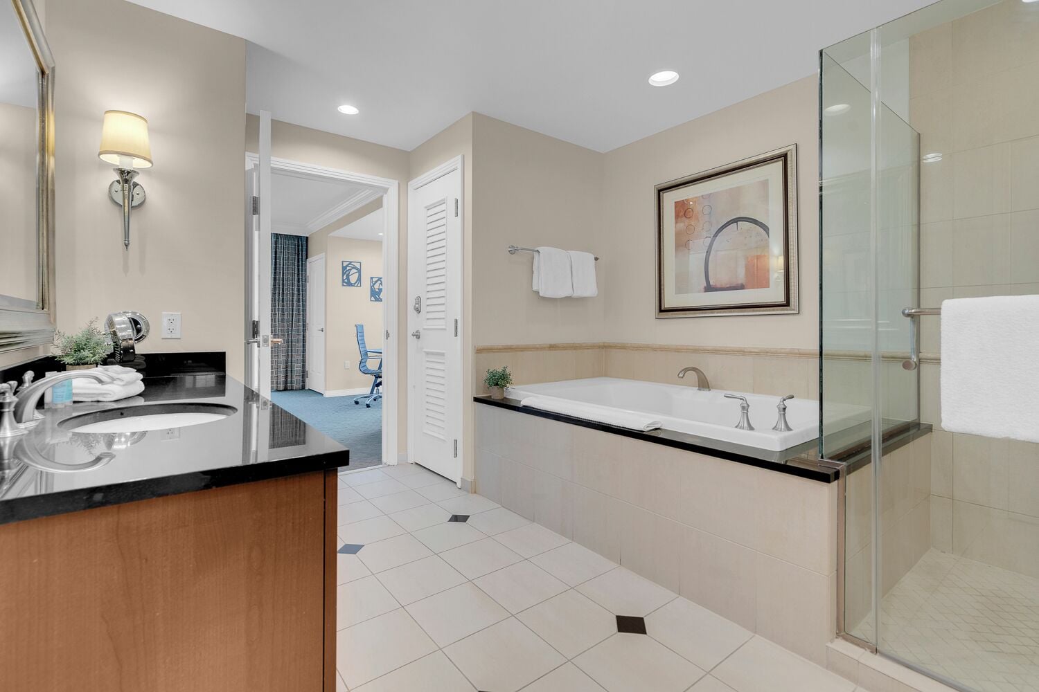 A modern bathroom with a large sink, a bathtub, and a glass shower enclosure.