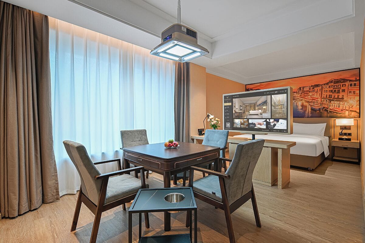 Ein Hotelzimmer mit Essbereich, einem Bett, einem Fernseher und einem Stadtbild.