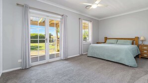 A bedroom with a bed, a nightstand, a ceiling fan, and a sliding glass door leading to a balcony. - Leisurely Long Swamp Retreat - 3 Bed, 2 Bath (Forest Reefs)