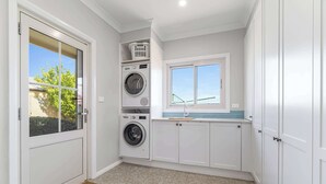 A laundry room with a washing machine, dryer, and stacked laundry baskets. - Leisurely Long Swamp Retreat - 3 Bed, 2 Bath (Forest Reefs)